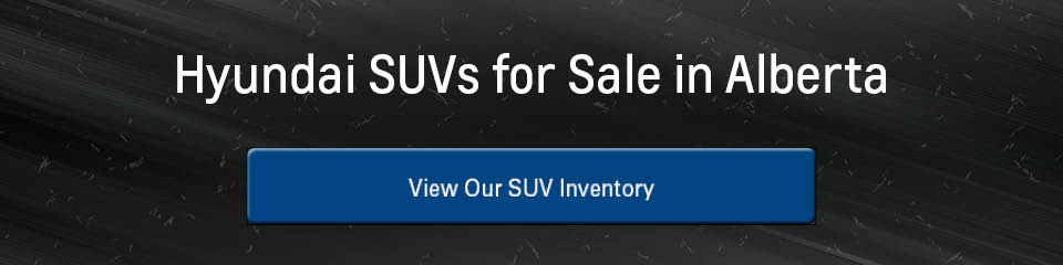 A banner with a dark, snowy roadway in the background, the words 'Hyundai SUVs for Sale in Alberta' in white at the top, and a blue button that says 'View Our SUV Inventory' at the bottom. The button turns grey on mouseover.